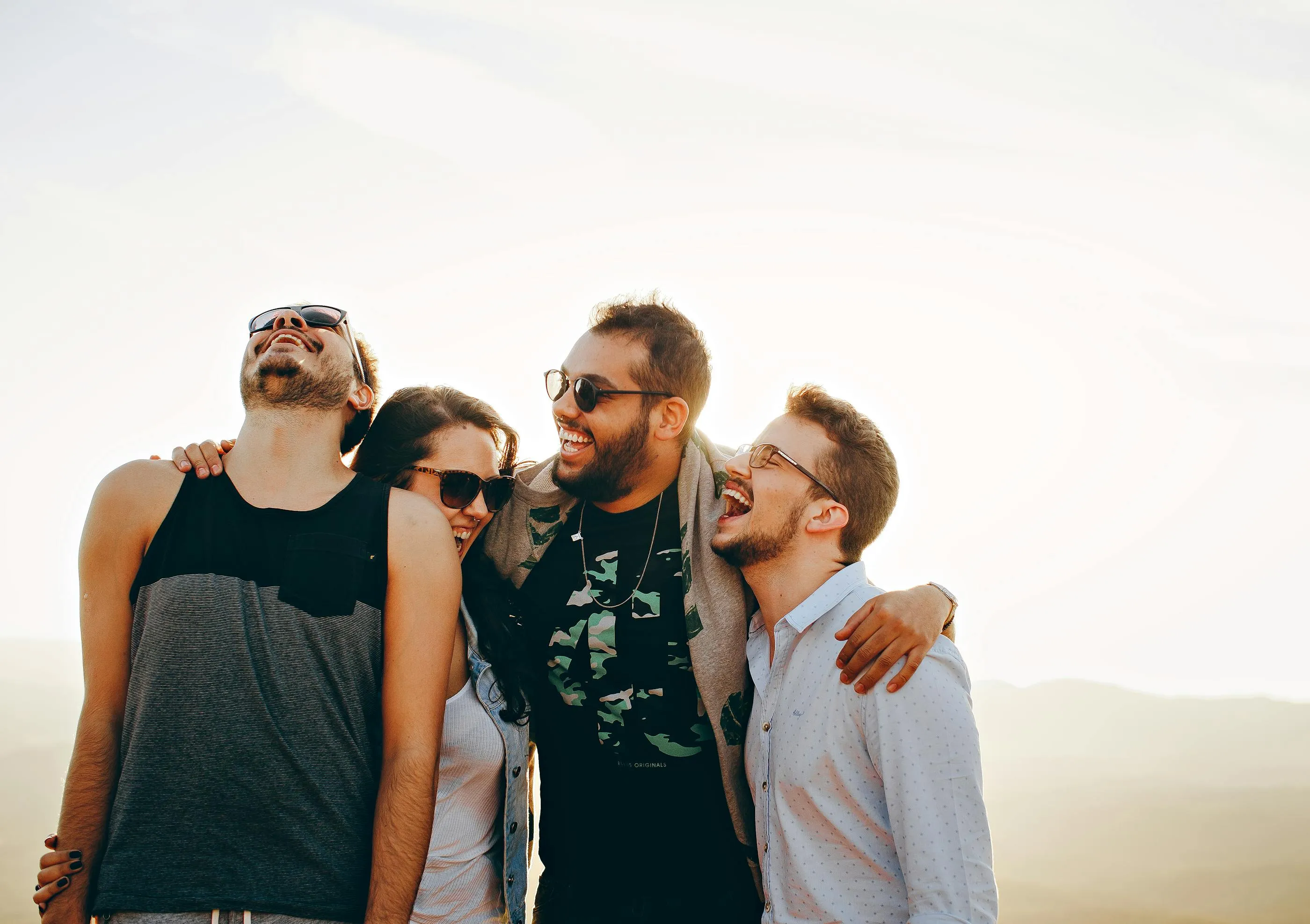 Friends laughing together outdoors in the sun